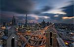 Cityscape of the Dubai, United Arab Emirates, with the Burj Khalifa and other skyscrapers under a cloudy sky.