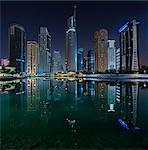 Cityscape of Dubai, United Arab Emirates at night, with illuminated skyscrapers lining the waterfront.