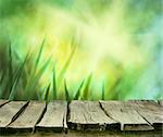 Spring background. Spring grass. Blur background. Summer nature. Bokeh blurred background.Wooden table. Wood planksGrass  with copyspace. Floral background .Nature bokeh