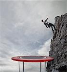 Businessman jumping on a trampoline to reach the flag at the top of the mountain. Achievement business goal and Difficult career concept
