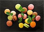 Sweet colorful macarons on black stony table