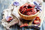 Bowl with sun-dried tomatoes and fork on wooden table,selective focus.