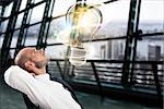 Businessman looks a big light bulb in his office. Great business idea concept