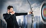 Businessman with bow and arrow aiming a target