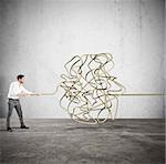 Businessman trying to solve the complicated tangle