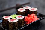 Fresh delicious tuna maki sushi rolls on dark background, japanese food