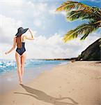 Woman walking on the tropical beach shore