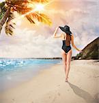 Woman walking on the tropical beach shore