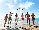 Group of friends run to the blue sea with an aircraft in the sky. Concept of travel and summer