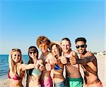 Happy group of friends having fun on the beach. Concept of summertime