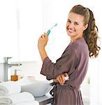 Portrait of smiling woman with toothbrush in bathroom