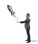 Businessman holding a small rocket. Startup of a new company concept