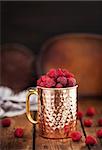 Fresh ripe raspberries in a copper mug