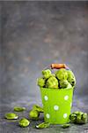 Organic fresh raw brussels sprouts in a metal bucket on gray background, copy space