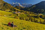 Two brothers admires the village of Santa Magdalena, Funes valley, Odle dolomites, South Tyrol region, Trentino Alto Adige, Bolzano province, Italy, Europe