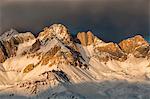 A fiery winter sunset towards the Sasso di Valfredda. From the left Punta Jigole, Sasso Vernale, Cima Ombrettola, Sasso Valfredda and Formenton. Behind them, covered by clouds the immense south face of the Marmolada. Dolomites, Italy