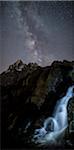 The milky way over Monviso lights up a little waterfall. Cozian Alps, Piedmont, Italy. Europe