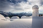 Winter sun shining behind the pictoresque bell tower at Alpe Scima after an heavy snowfall. Valchiavenna, Valtellina Lombardy Italy Europe