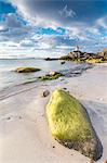 Midnight sun lights up cliffs and sandy beach surrounded by turquoise sea Eggum Unstad Vestvagøy Lofoten Islands Norway Europe