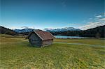 Wooden hut frames the alpine lake surrounded by the Alps Geroldsee Krün Garmisch Partenkirchen Upper Bavaria Germany Europe