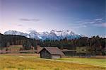 Wooden hut frames the alpine lake surrounded by the Alps Geroldsee Krün Garmisch Partenkirchen Upper Bavaria Germany Europe