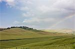 The rainbow frames the green hills and typical cypresses of Crete Senesi (Senese Clays) province of Siena Tuscany Italy Europe