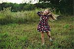 Blond haired girl running and pulling a face in field