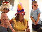 Mother, son and daughter playing dress up, wearing funny hats and glasses, laughing