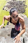 Young female free runner climbing up sea wall