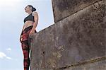 Young female free runner looking out from sea wall