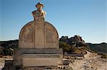 Monument of Charloun Rieu and view of distant town and castle, Les Baux-de-Provence, Provence-Alpes-Côte d'Azur, France
