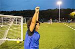 Female football player jubilant, Hackney, East London, UK