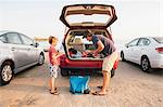 Father and son taking fishing rods from car boot, Goleta, California, United States, North America