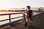 Father and son on pier with fishing rods, Goleta, California, United States, North America