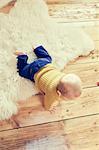 Overhead view of baby boy crawling on floorboards