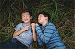 Brothers lying on grass together