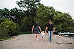 Pregnant couple strolling on beach with male toddler son, Lake Ontario, Canada