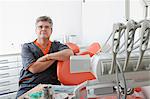 Dentist sitting by dental chair