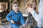 Girl and father grooming pet dog in living room