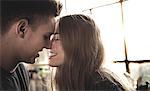 Smiling young man and woman leaning in for a kiss.