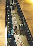 High angle view of woman sitting at a bar counter looking up at the camera, smiling.