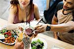 Friends clinking glasses while dining together in restaurant