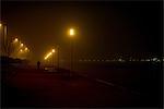 Person walking along deserted waterfront at night