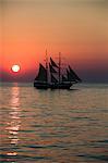 A tall ship sailing in the Aegean Sea while the sun is setting Santorini Cyclades Greece Europe