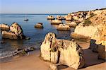 Runner on the fine sandy beach bathed by the blue ocean at dawn Praia do Alemao Portimao Faro district Algarve Portugal Europe