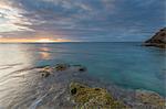 The lights of sunset are reflected in the blue sea Hawksbill Bay Caribbean Antigua and Barbuda Leeward Islands West Indies