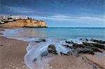 Ocean waves crashing on rocks and beach surrounding Carvoeiro village at sunset Lagoa Municipality Algarve Portugal Europe