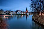 The lights of dusk on typical houses and the cathedral reflected in river Trave Lübeck Schleswig Holstein Germany Europe