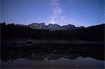 Stars on the peaks of Latemar mountain range reflected in Lake Carezza Ega Valley Province of Bolzano South Tyrol Italy Europe