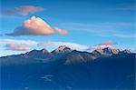 Pink clouds and blue sky lights up the rocky peaks of the Rhaetian Alps at dawn Valtellina Lombardy Italy Europe